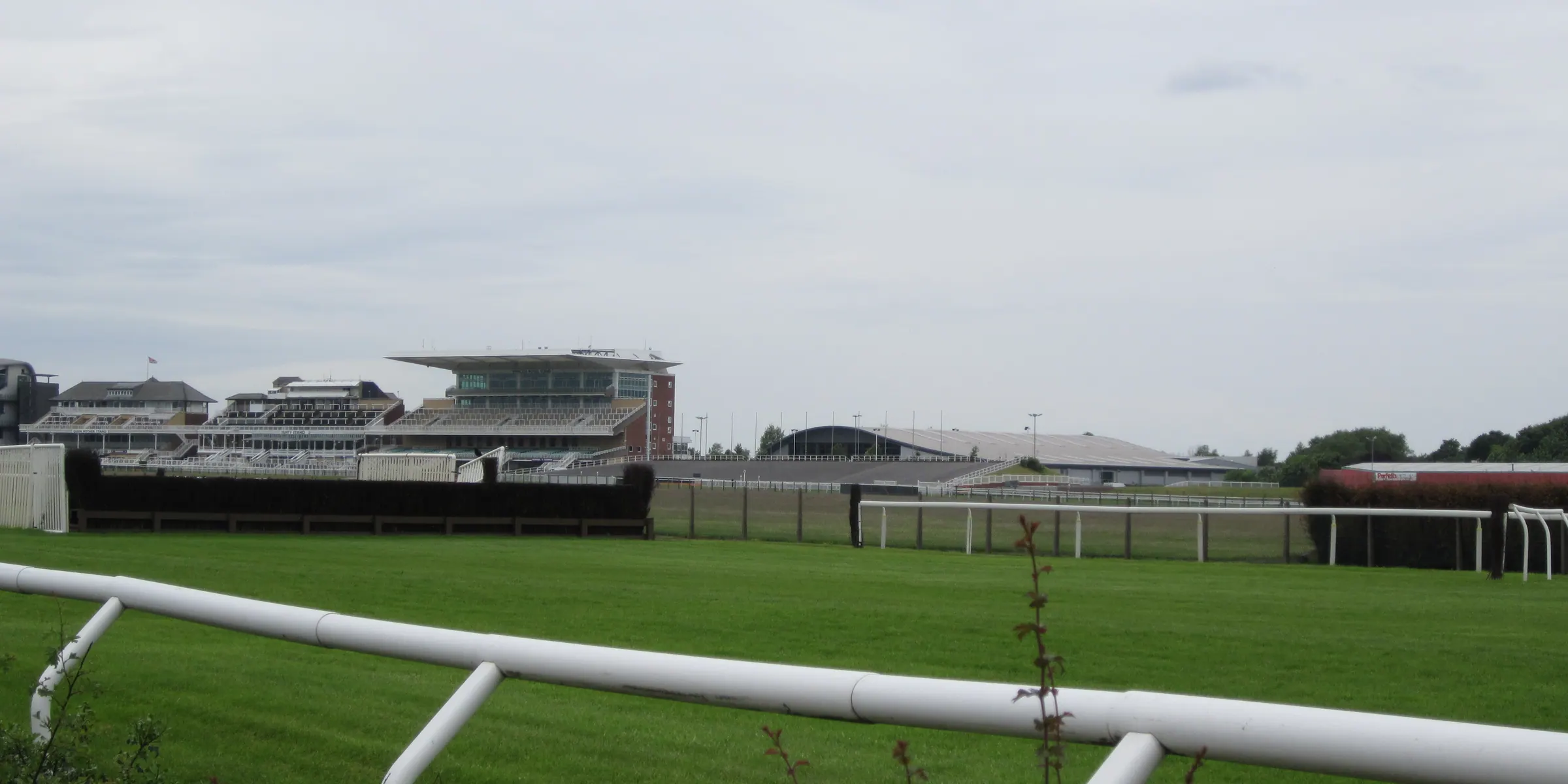 White rails and plain fences at Aintree beneath a grey sky