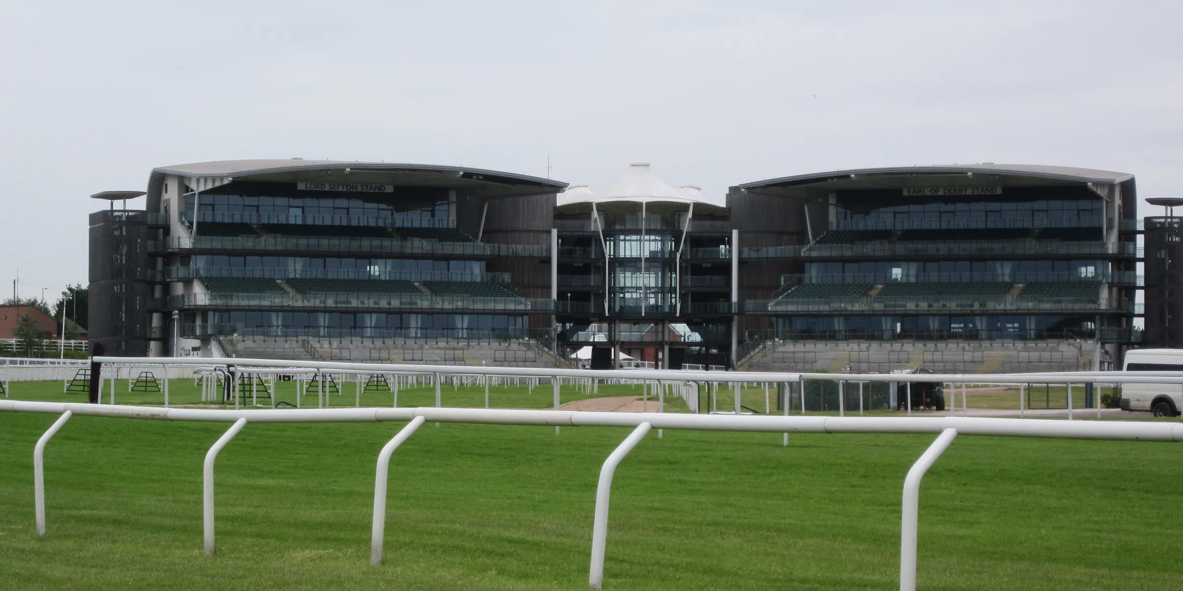 Aintree grandstands across the grass and white running rails