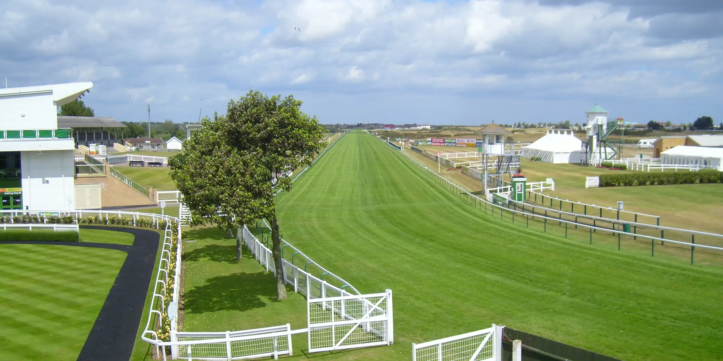The green straight at Great Yarmouth with white rails under a blue sky