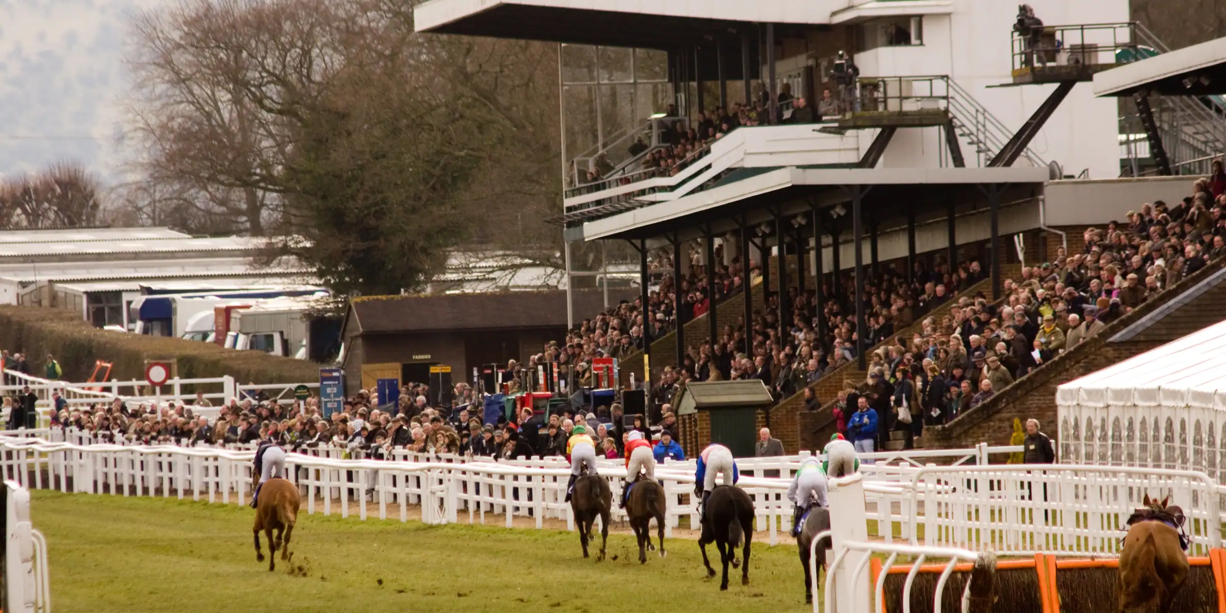 Horses and riders passing the stand and spectators at Plumpton